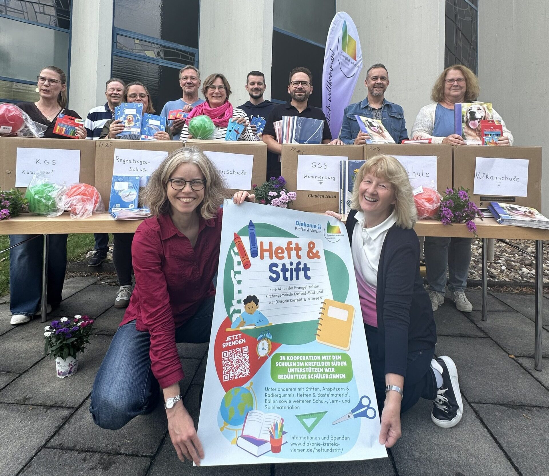 Vertreterinnen und Vertreter der sechs beteiligten Grundschulen, der Evangelischen Kirchengemeinde Krefeld-Süd und der Diakonie Krefeld & Viersen bei der Übergabe der Schul- und Spielmaterialien an der Markuskirche in Fischeln.